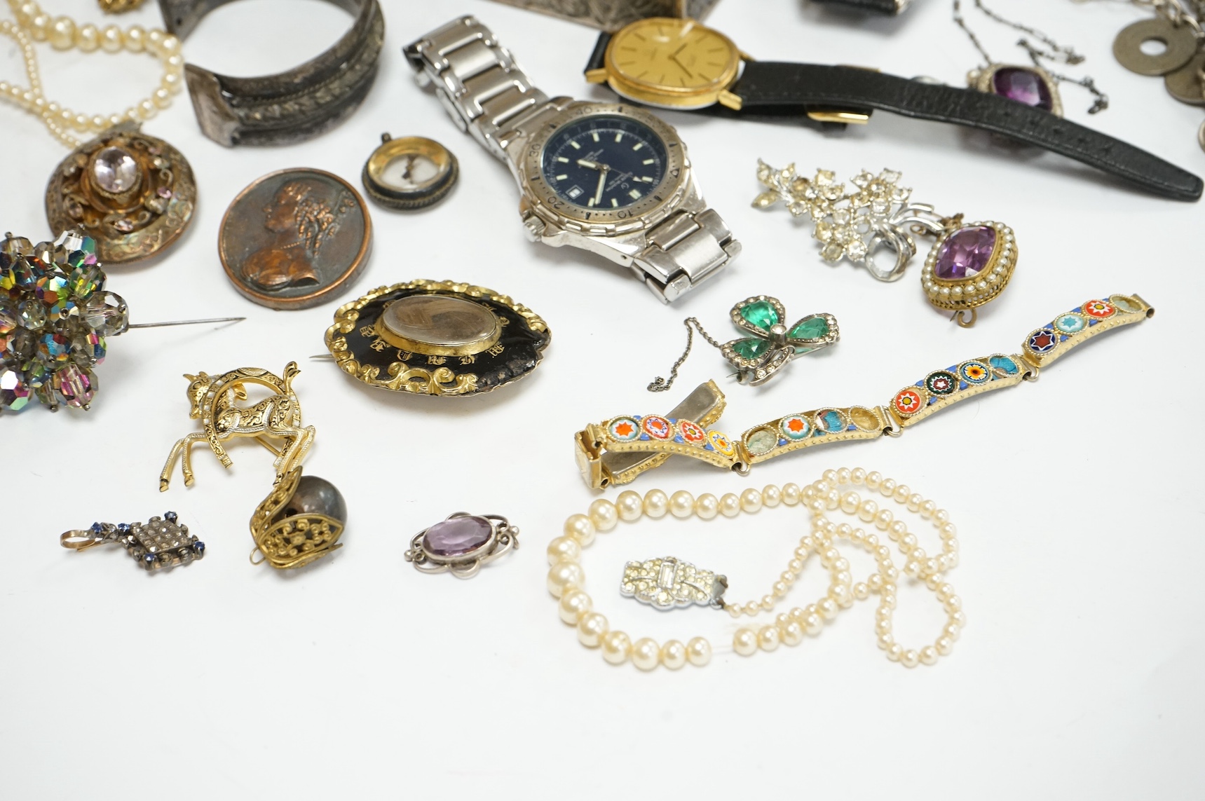 A group of assorted mainly costume and other jewellery including a silver bracelet hung with assorted coins and a Victorian enamelled mourning brooch, together with wrist watches, white metal box etc. Condition - poor to